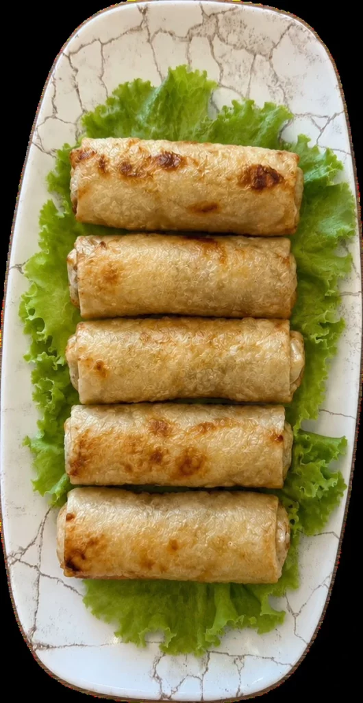 Nems frits dores servis avec salade, herbes fraiches et un bol de sauce